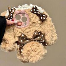 Plush toy with decorative bows on a plain background