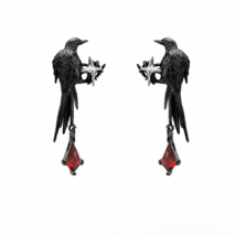 A close-up image of a person's ear wearing a Gothic style ear cuff with a dangle crow design and red rhinestone details.