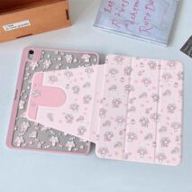 A hand holding a pink My Melody iPad case with cartoon character designs.