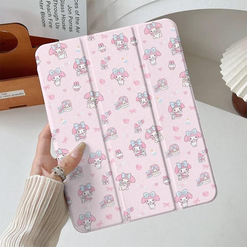 A hand holding a pink My Melody iPad case with cartoon character designs.
